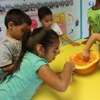Children scooping out a pumpkin