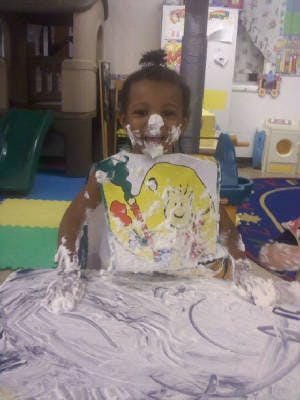 Child covered in white foam or shaving cream