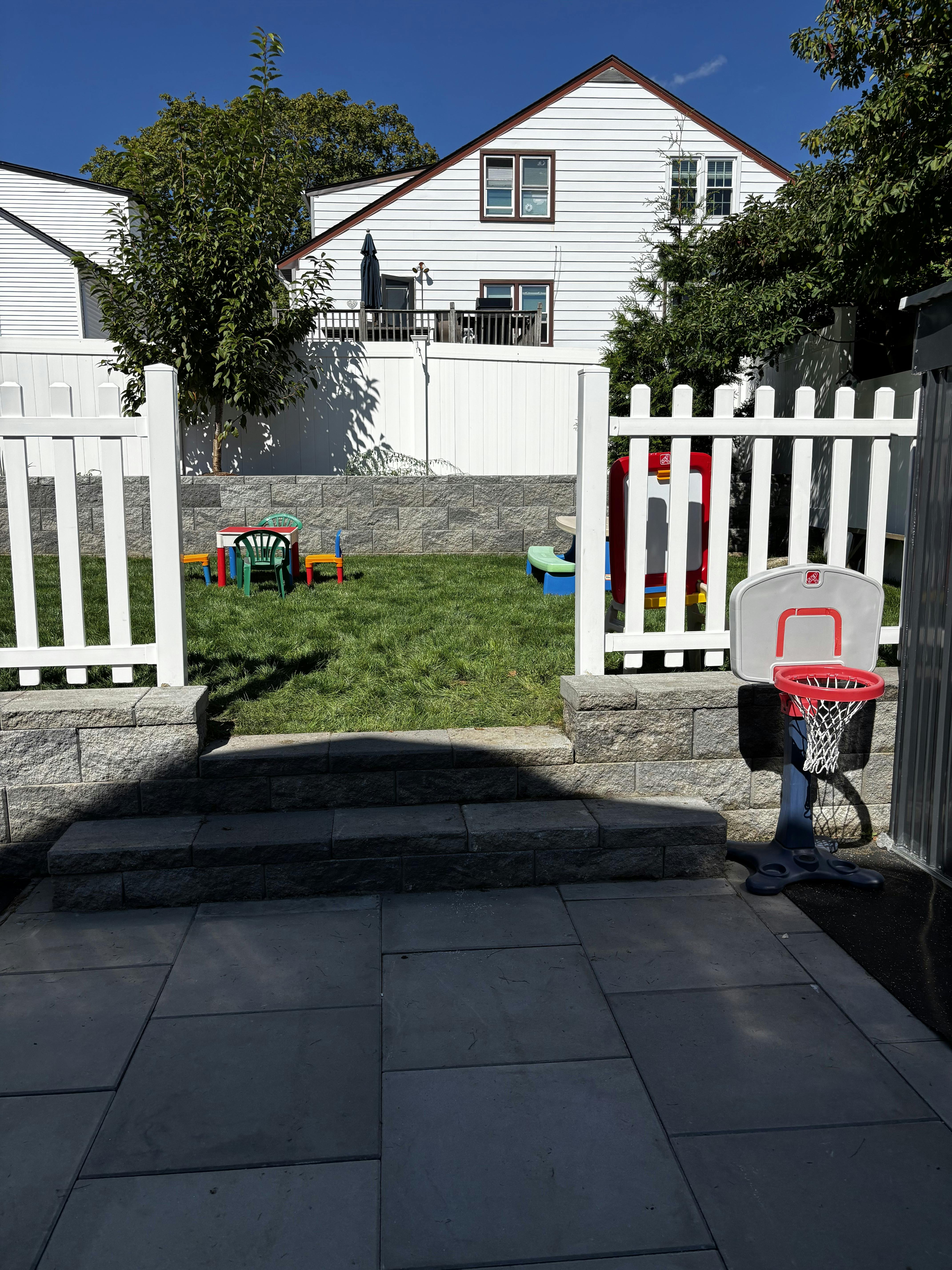 Backyard with a small basketball hoop and a play table