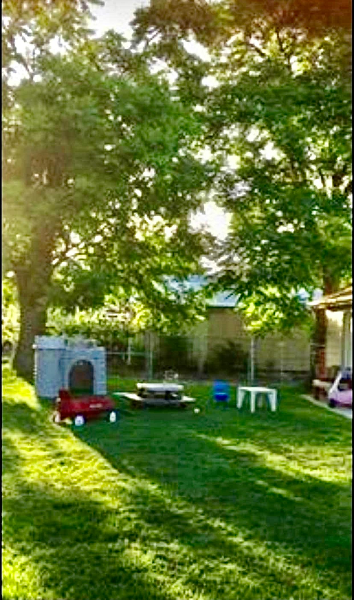 Backyard with playhouse, picnic table, and wagon