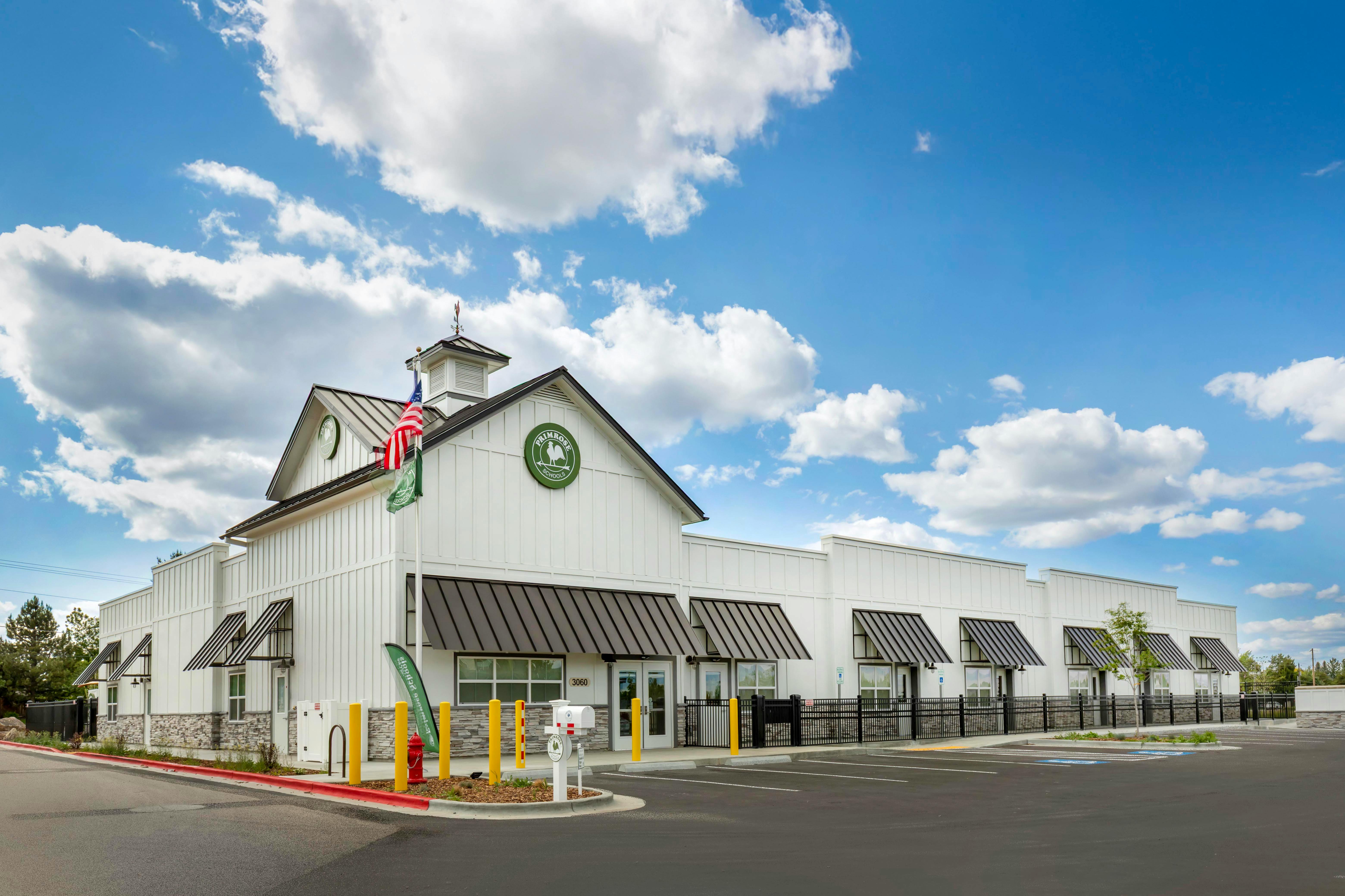 White Primrose Schools building with gray roofs and black awnings