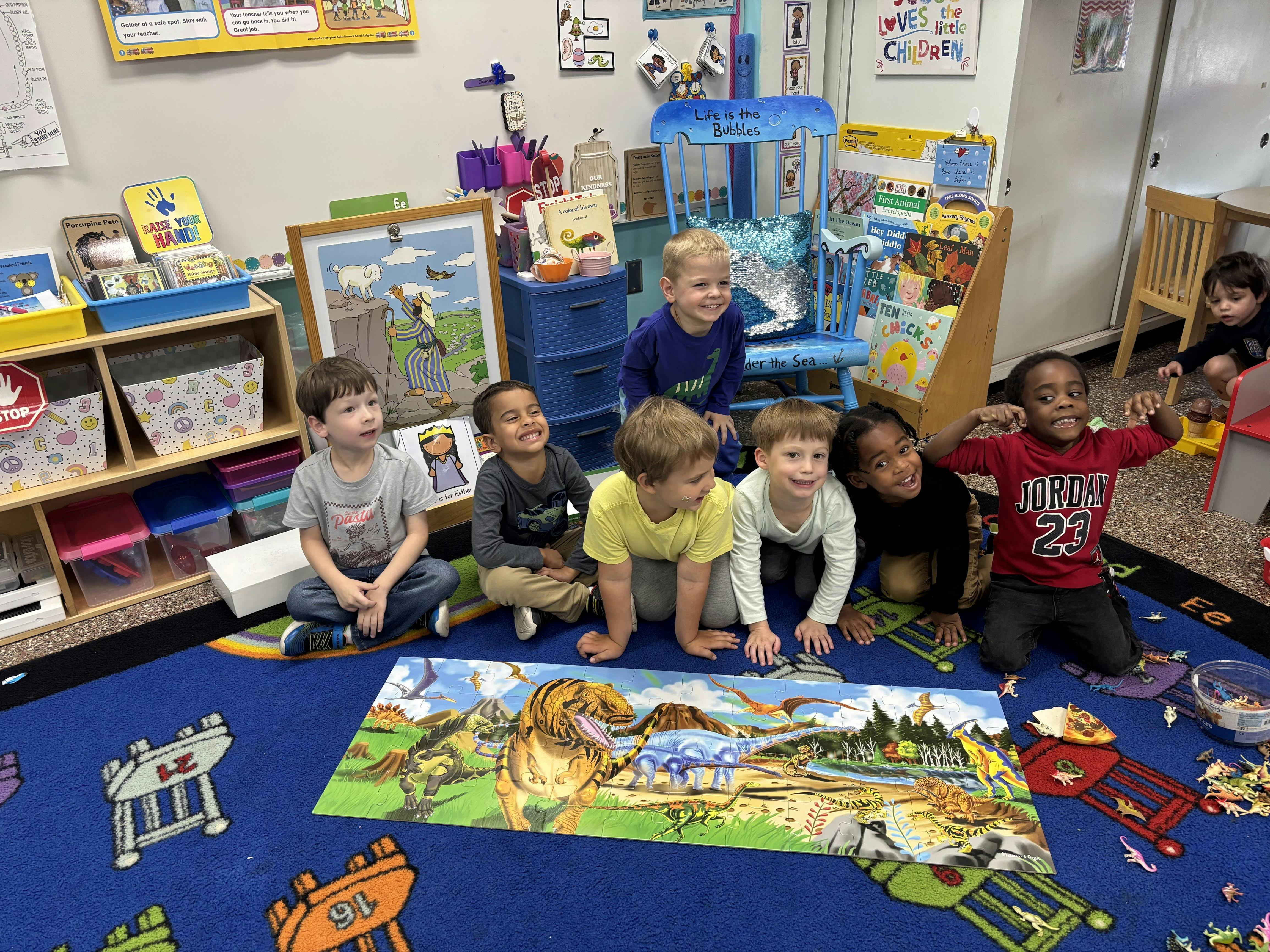 Group of children sitting on a rug with a large puzzle in-progress puzzle