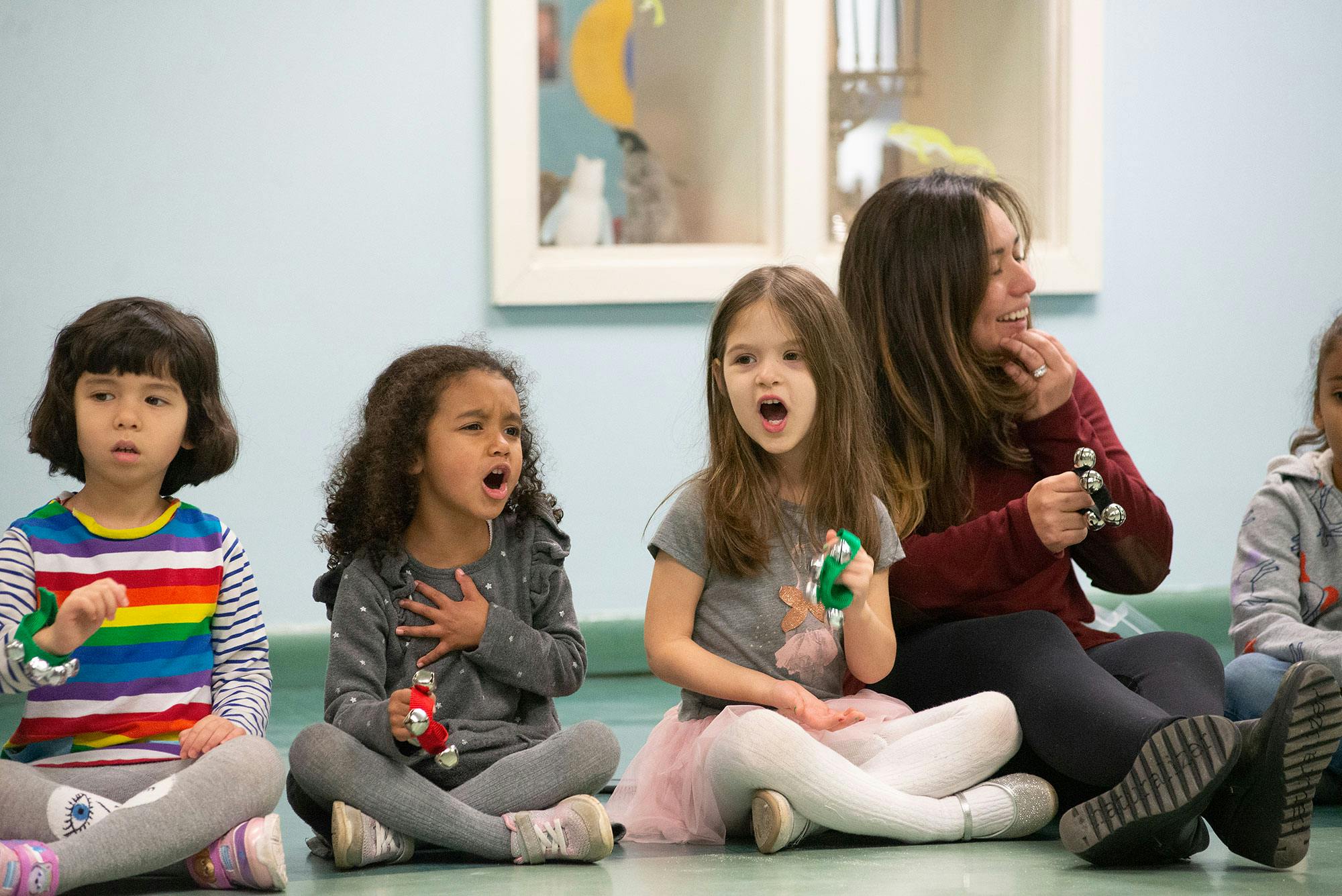 Adult and children sitting on floor, singing