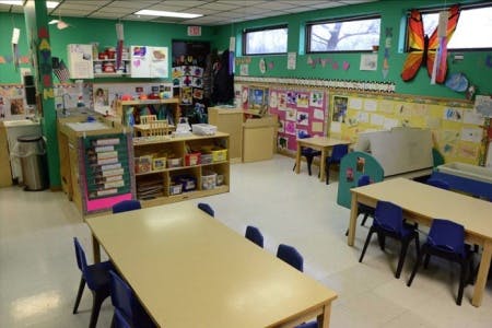 Classroom with tables, chairs, and shelves