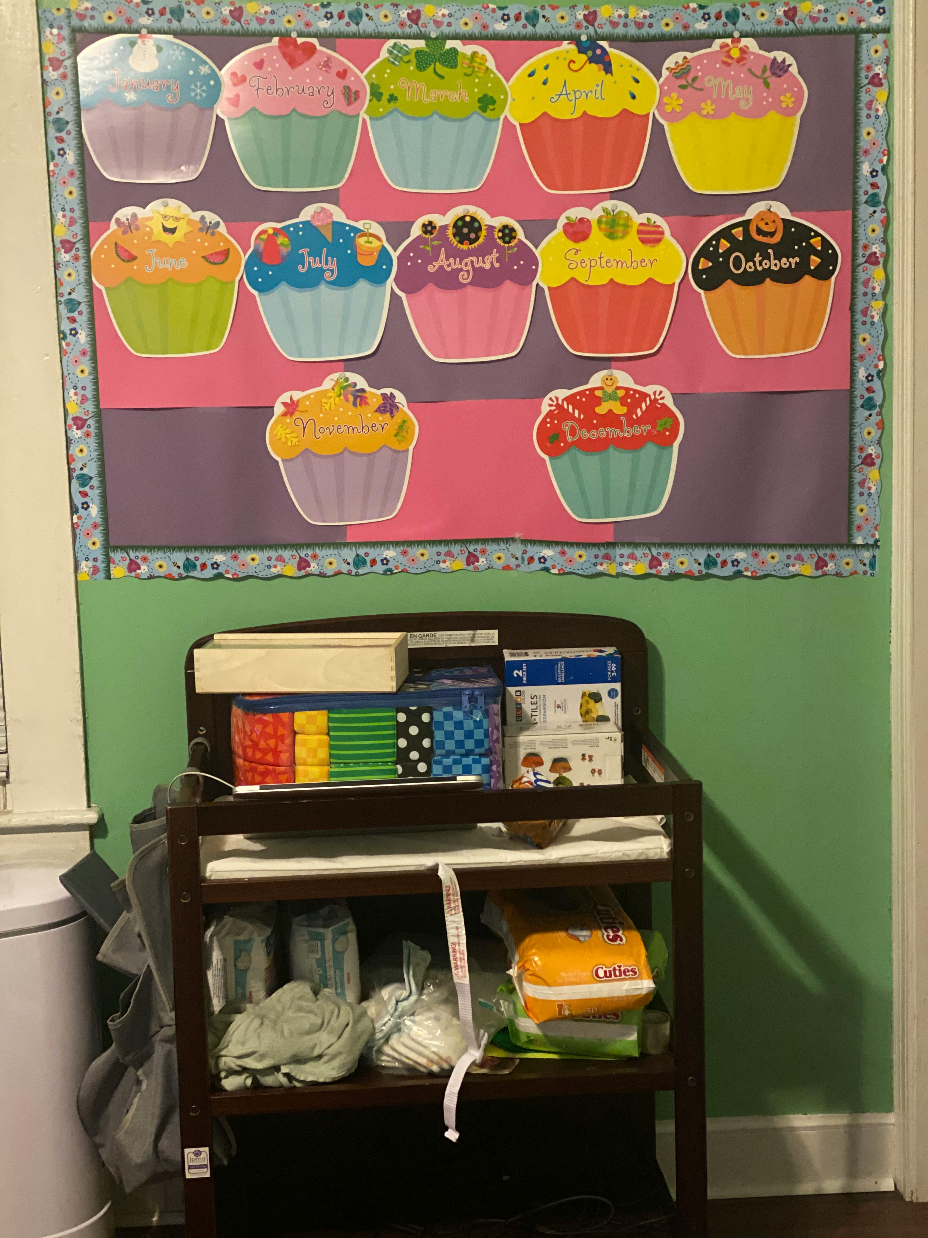 Cupcake-shaped cutouts with months of the year on a bulletin board