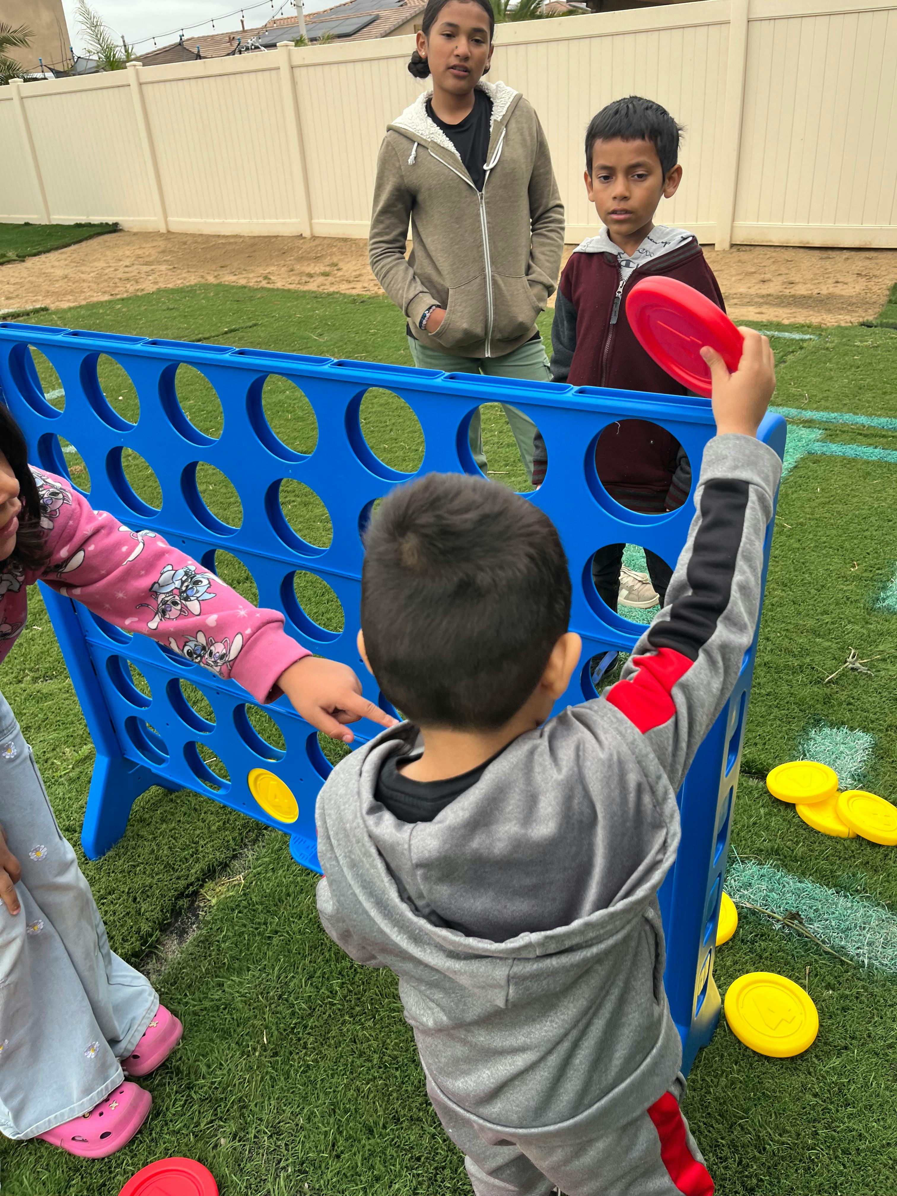 Children playing a giant Connect Four game outdoors