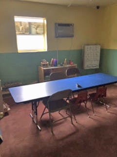 Empty classroom with blue tables and chairs