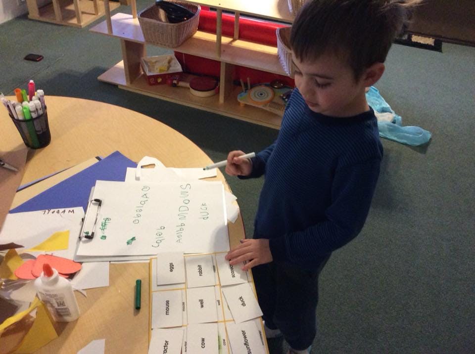 Child writing on a whiteboard at a table