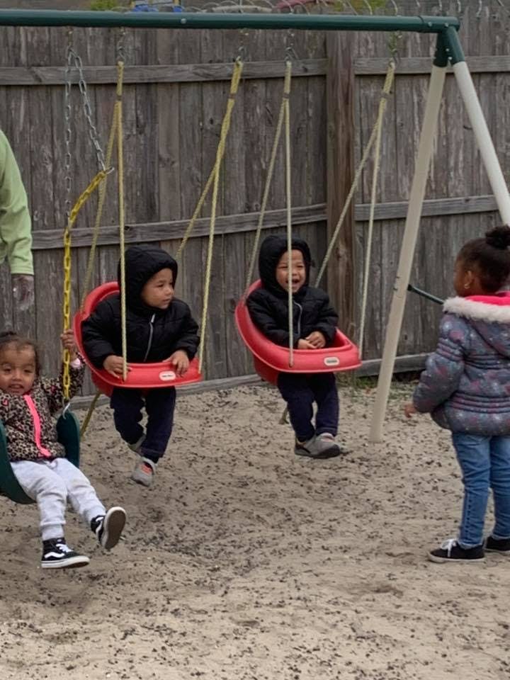 Three children on a playground swing set