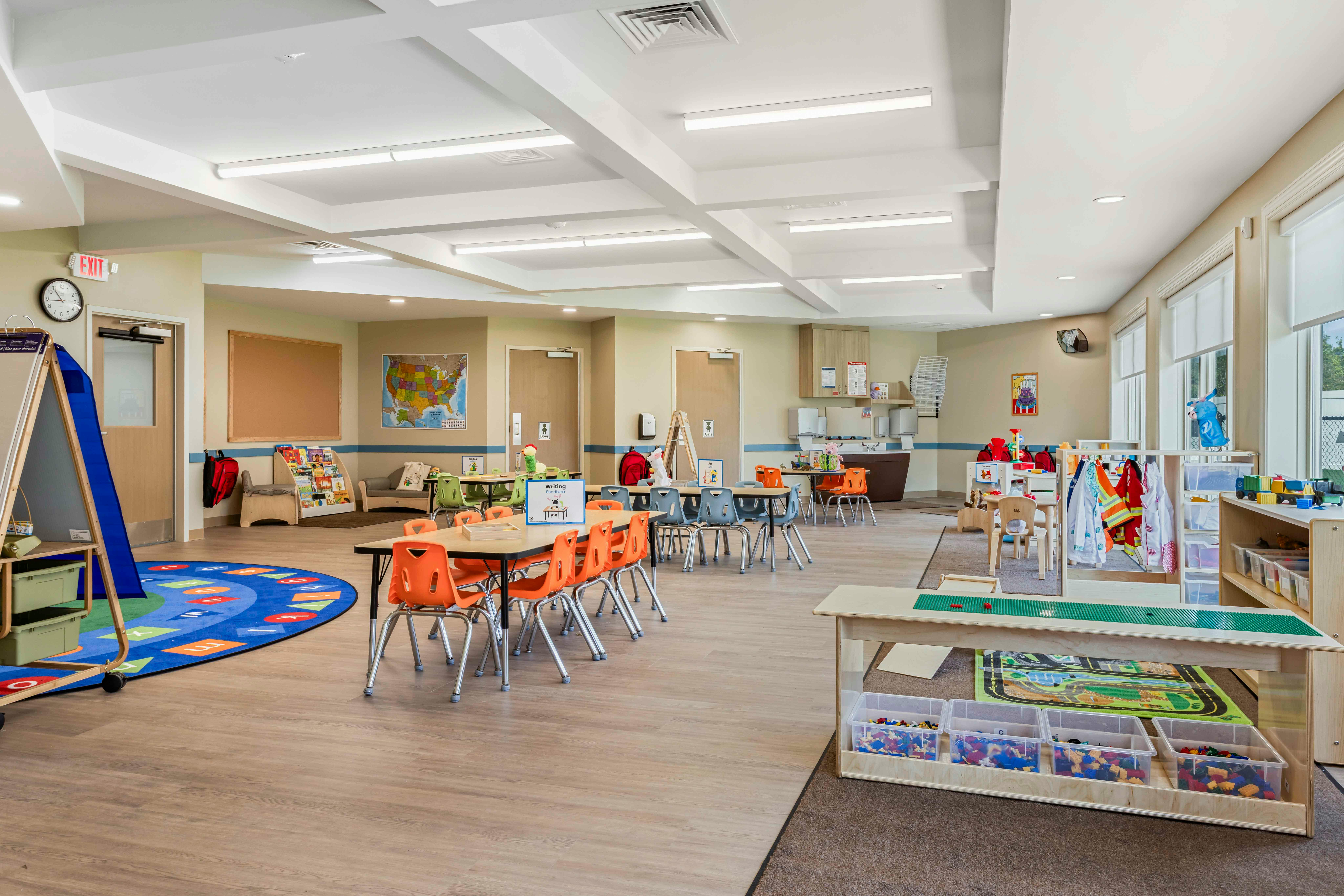 Classroom filled with small tables, chairs, learning materials, and toys