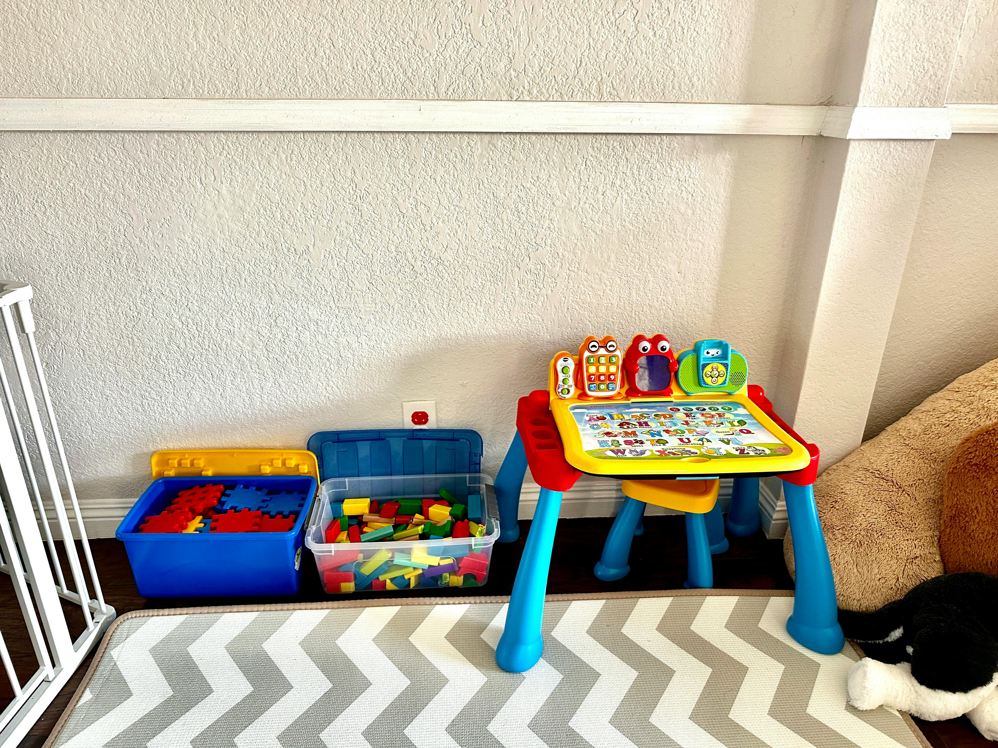 Child's activity table with toys and two bins of building blocks