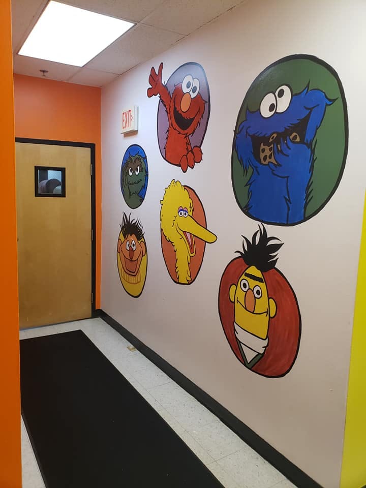 Hallway with Sesame Street character murals on the wall