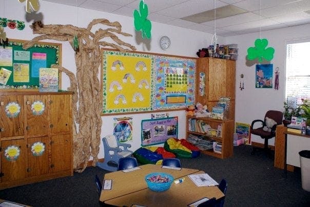 Classroom with bulletin boards, a tree decoration, and small tables