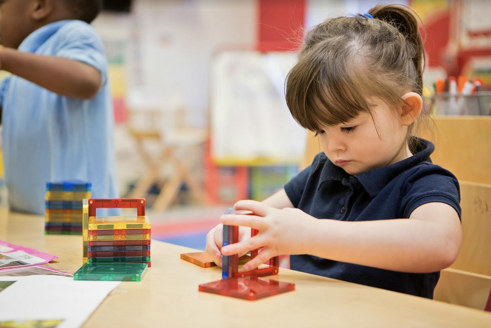 Child playing with colorful building blocks at a table
