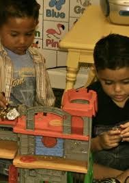 Two children playing with a toy castle
