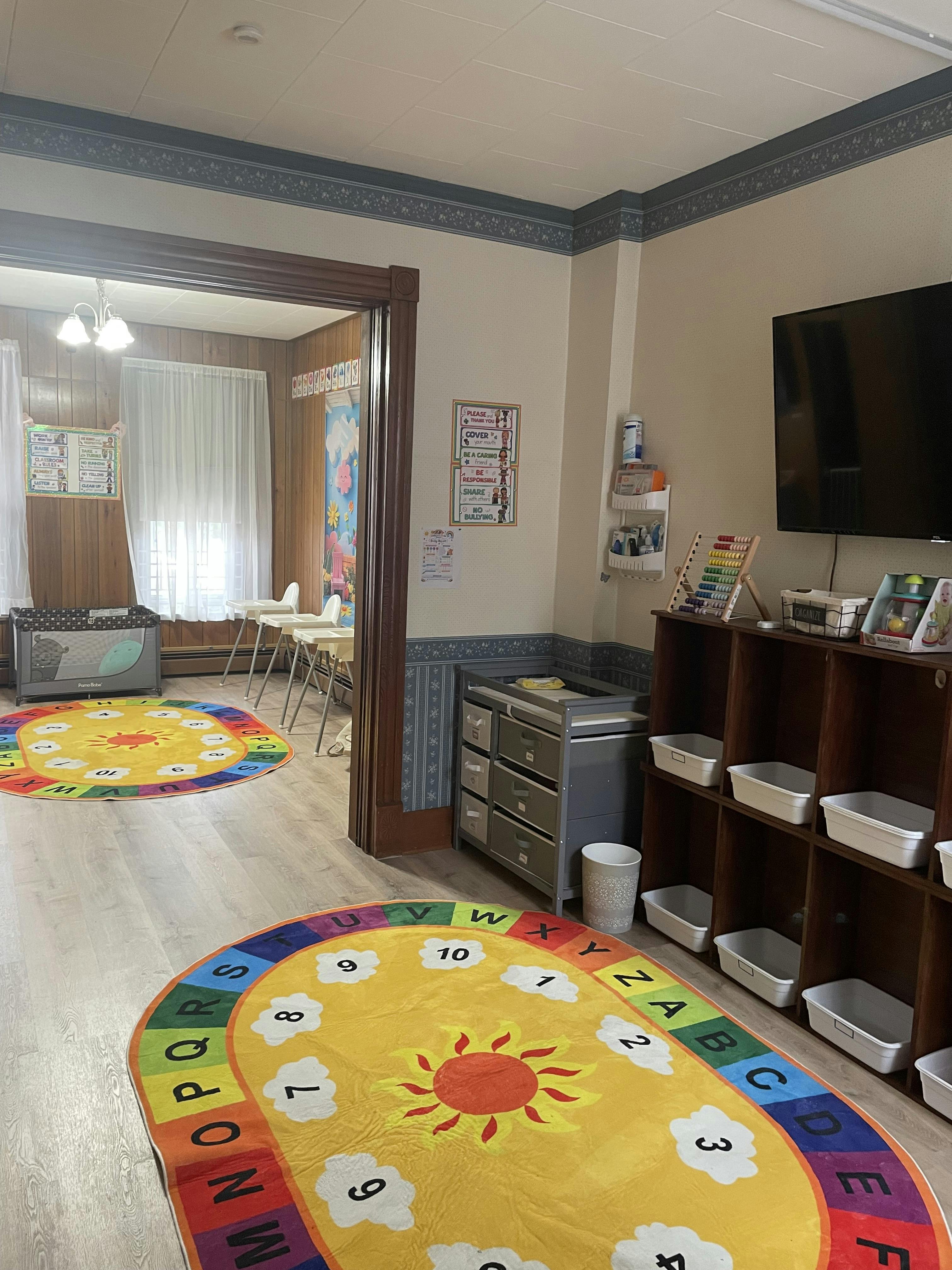 Colorful alphabet rugs and storage furniture in a child care room