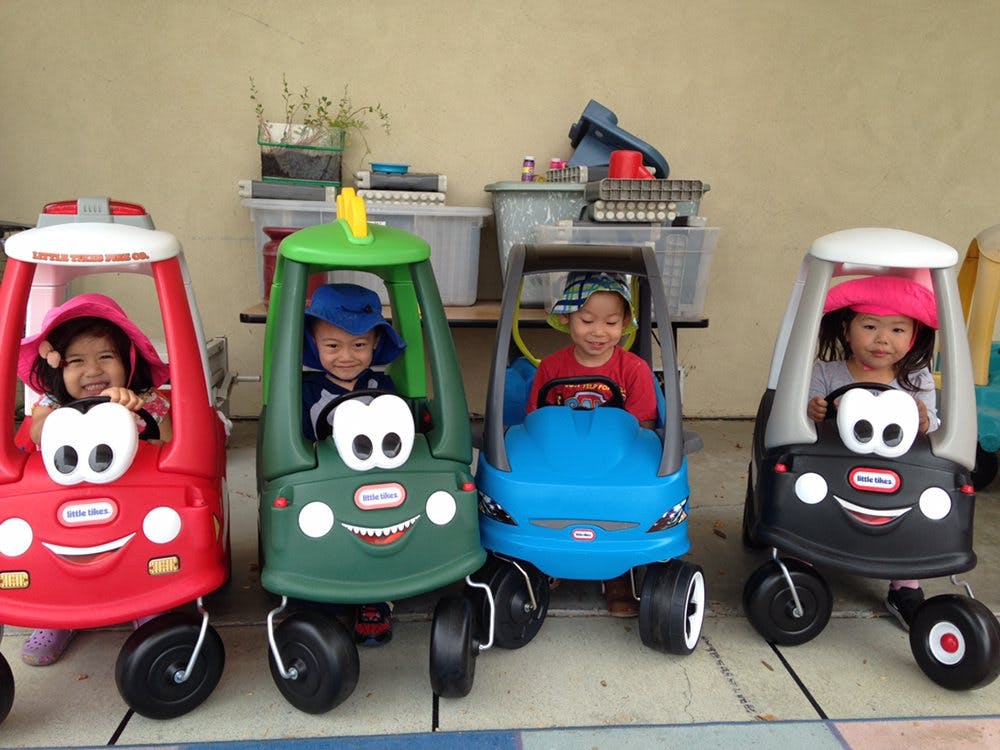 Four children in toy cars