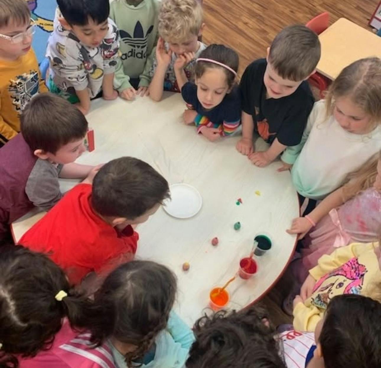Children gathered around a table looking at items