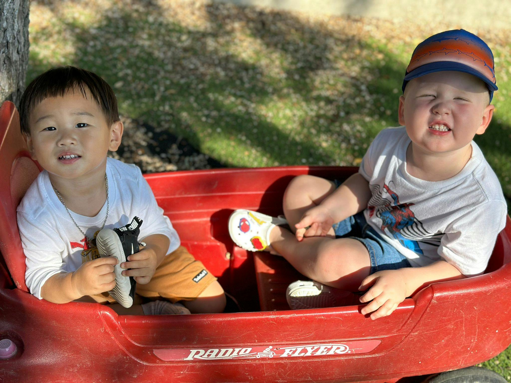 Two children sitting in a red wagon