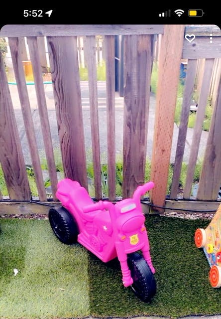 Pink toy motorcycle on artificial grass