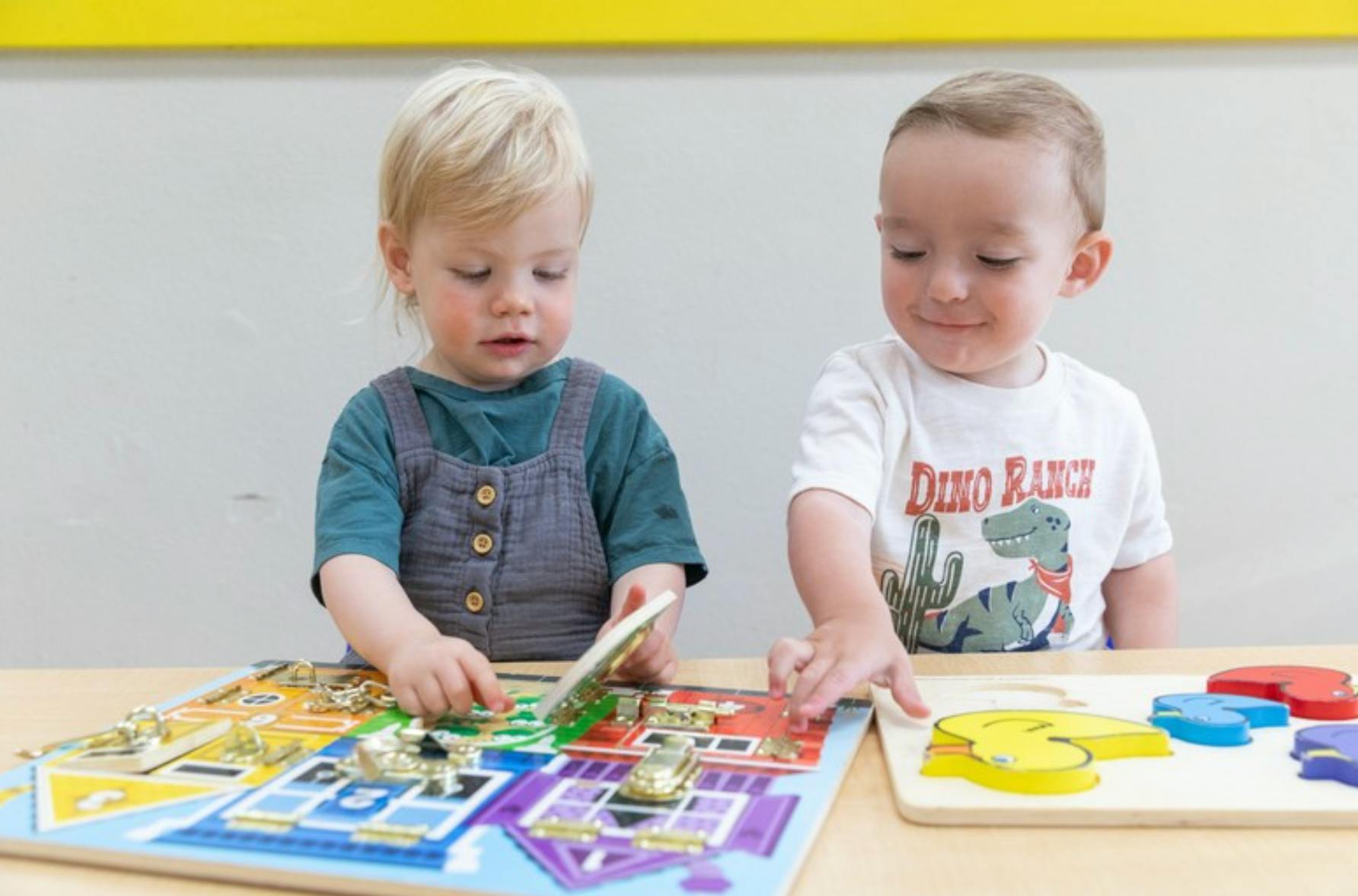 Two children playing with puzzles at a table