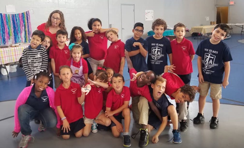 Adult and group of children posing for a photo