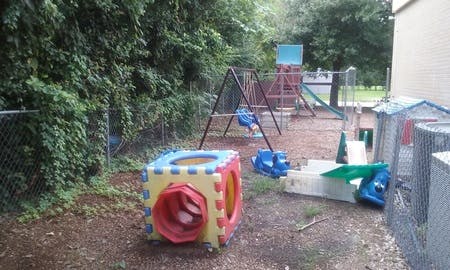 Outdoor playground with swings, slides, and a colorful play cube