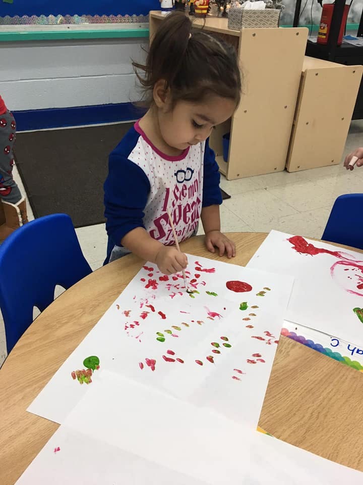 Child painting on paper at a table