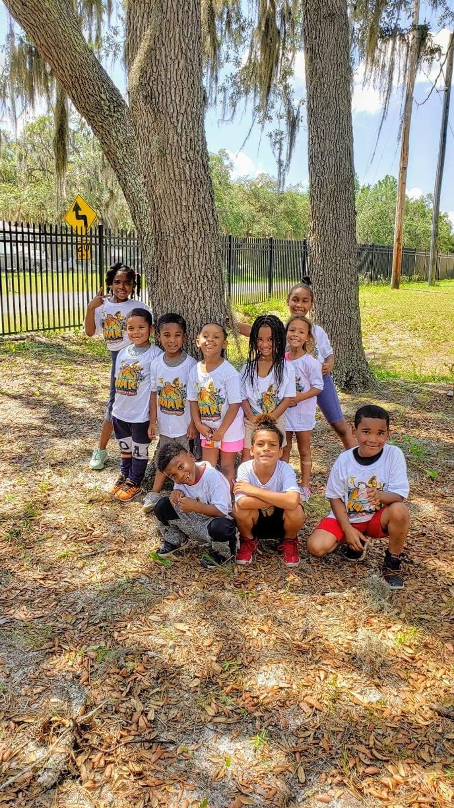 Group of children posing outdoors near trees