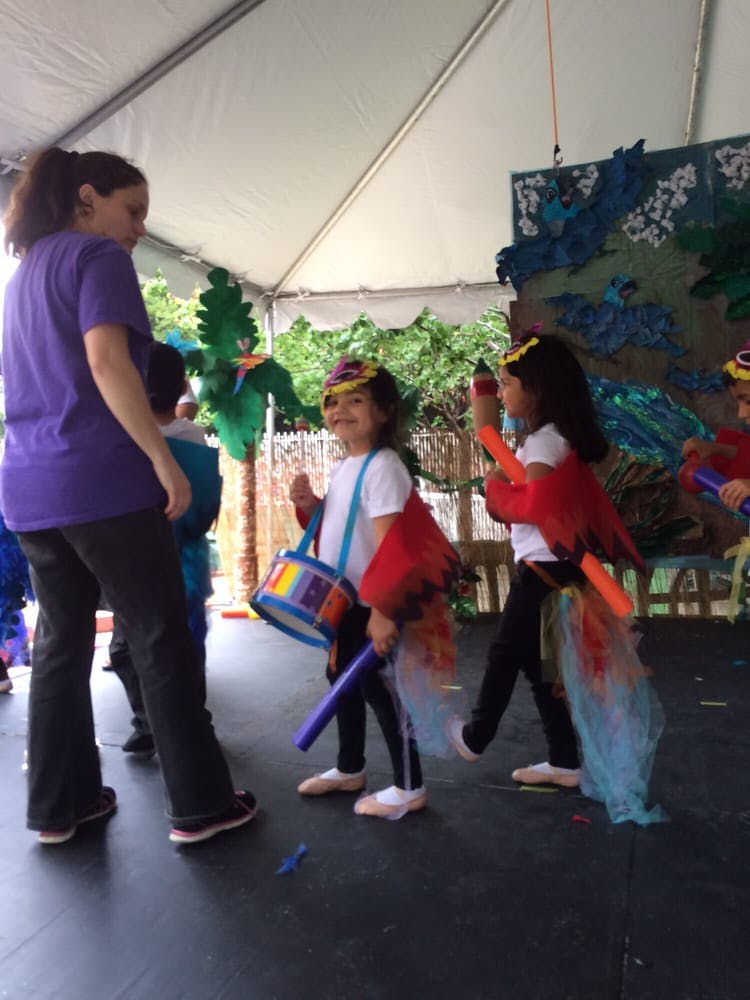 Person and children in costumes on a stage
