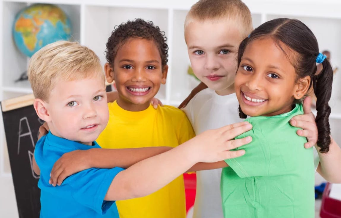 Four children standing together with arms around each other