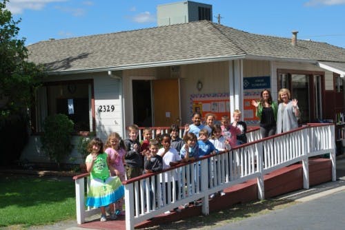 Group of children and adults standing on a ramp outside a building