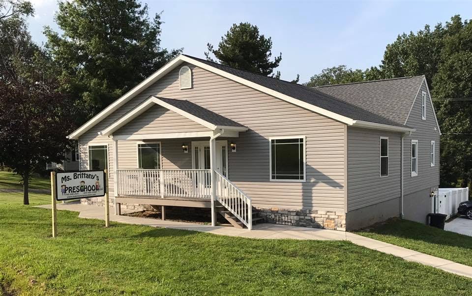 Gray house with a front porch and white railings