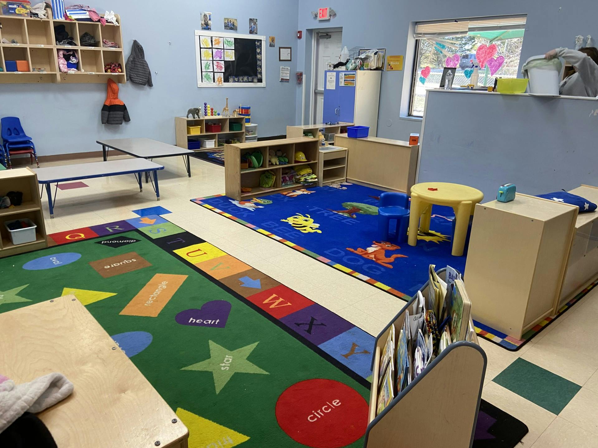 A classroom with colorful rugs and small tables