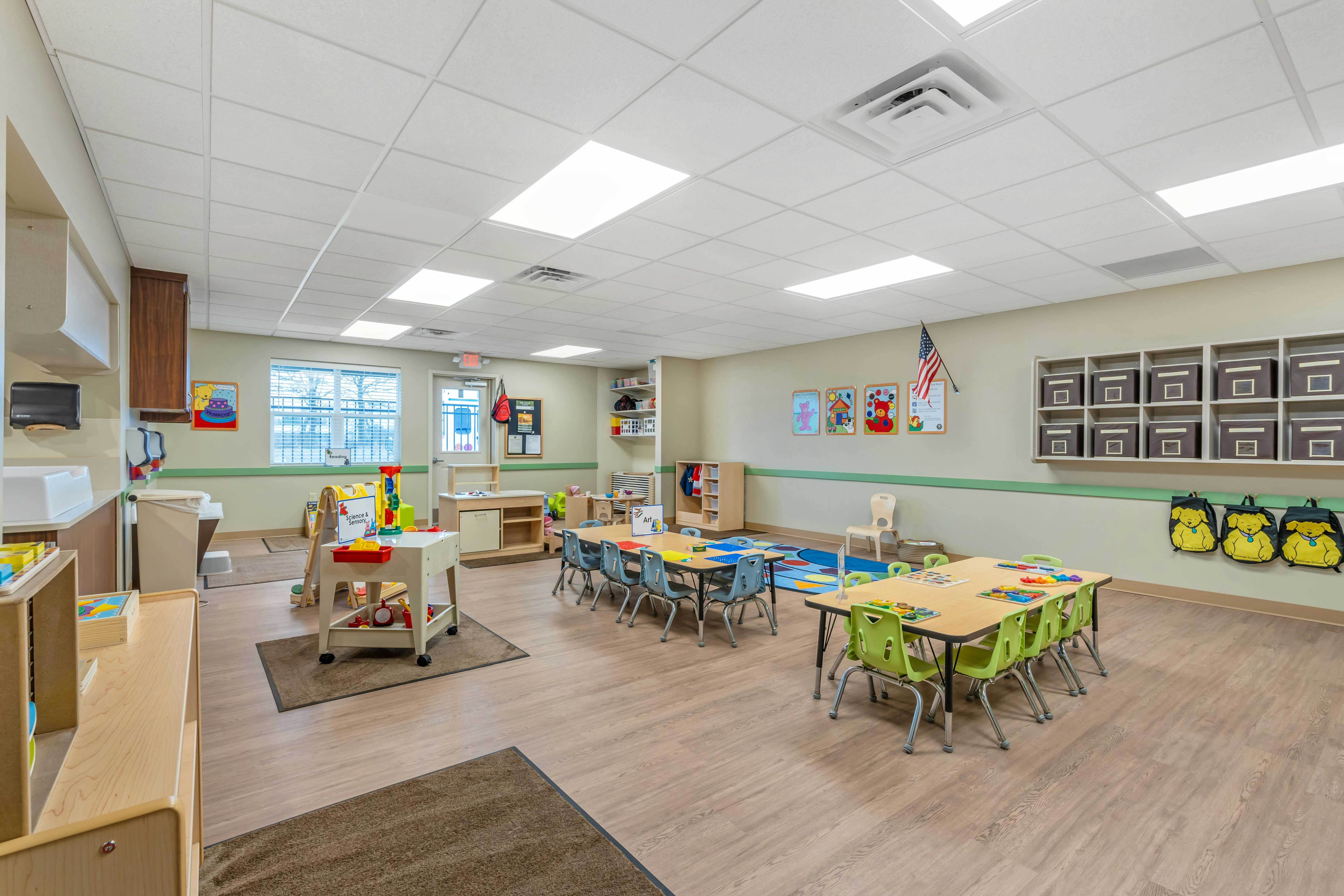 Empty colorful preschool classroom with small tables and chairs