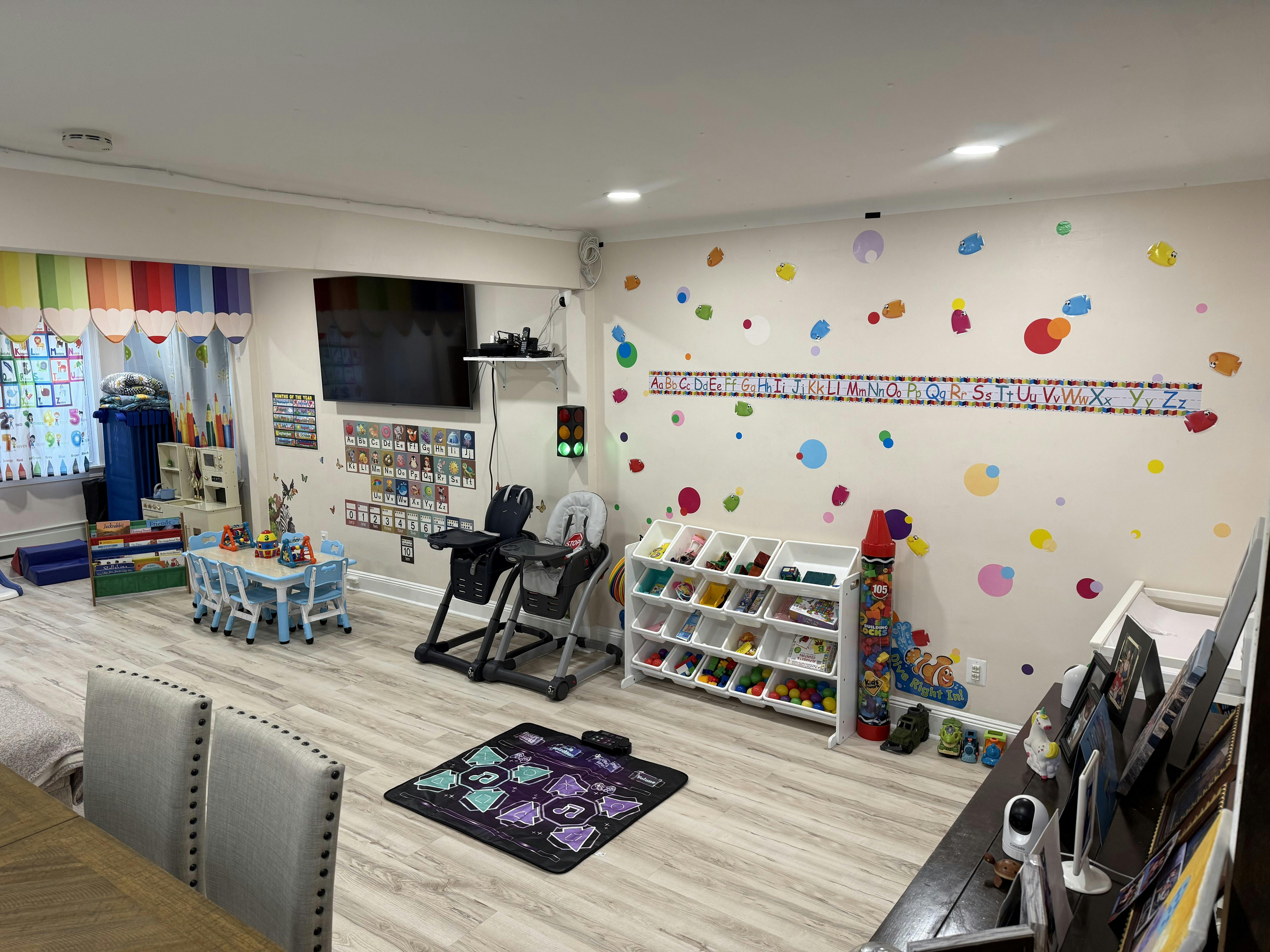 Playroom with colorful wall decals, small table and chairs, and toy storage