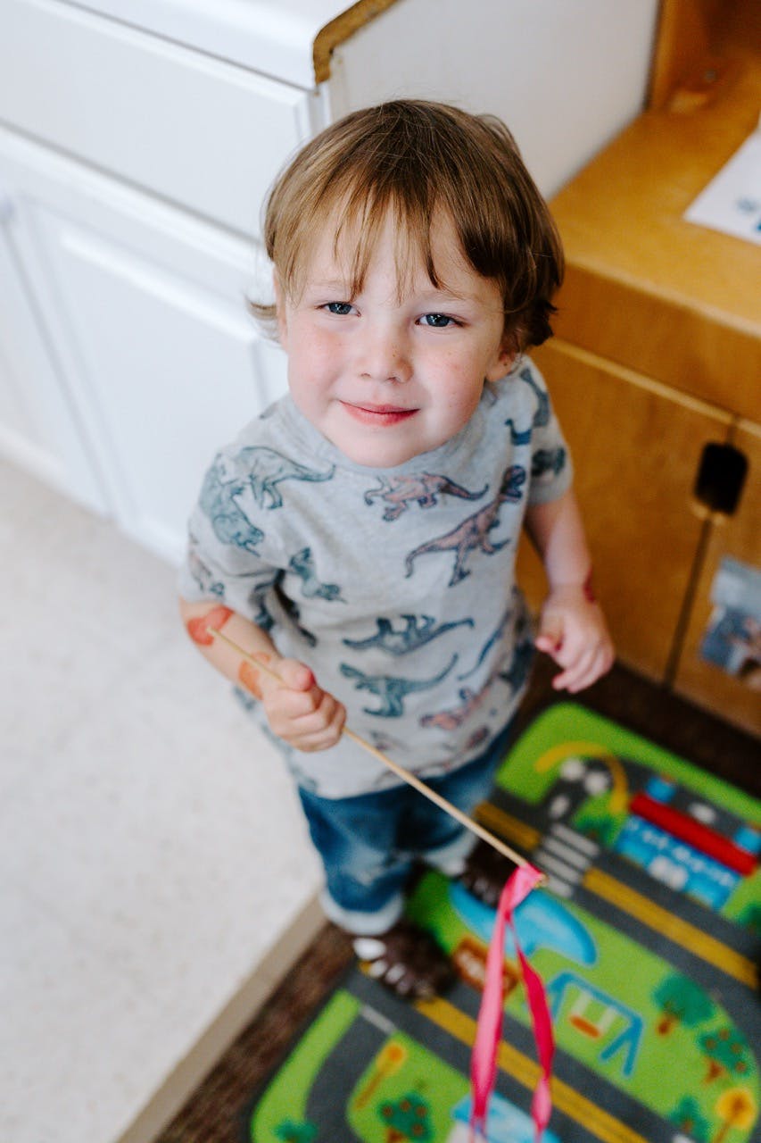 Child holding a stick with ribbons