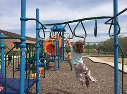 Child on monkey bars at a playground