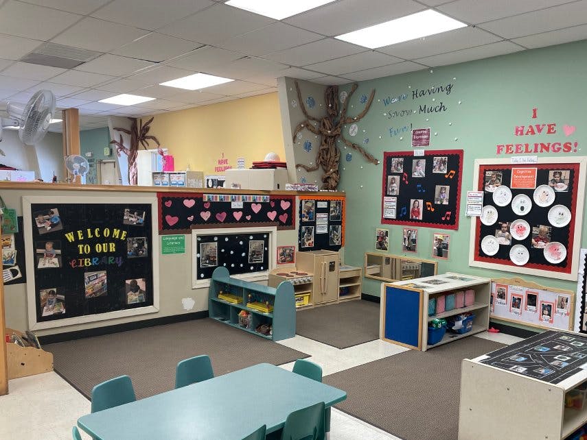 Classroom with child-sized furniture and colorful bulletin boards on the walls