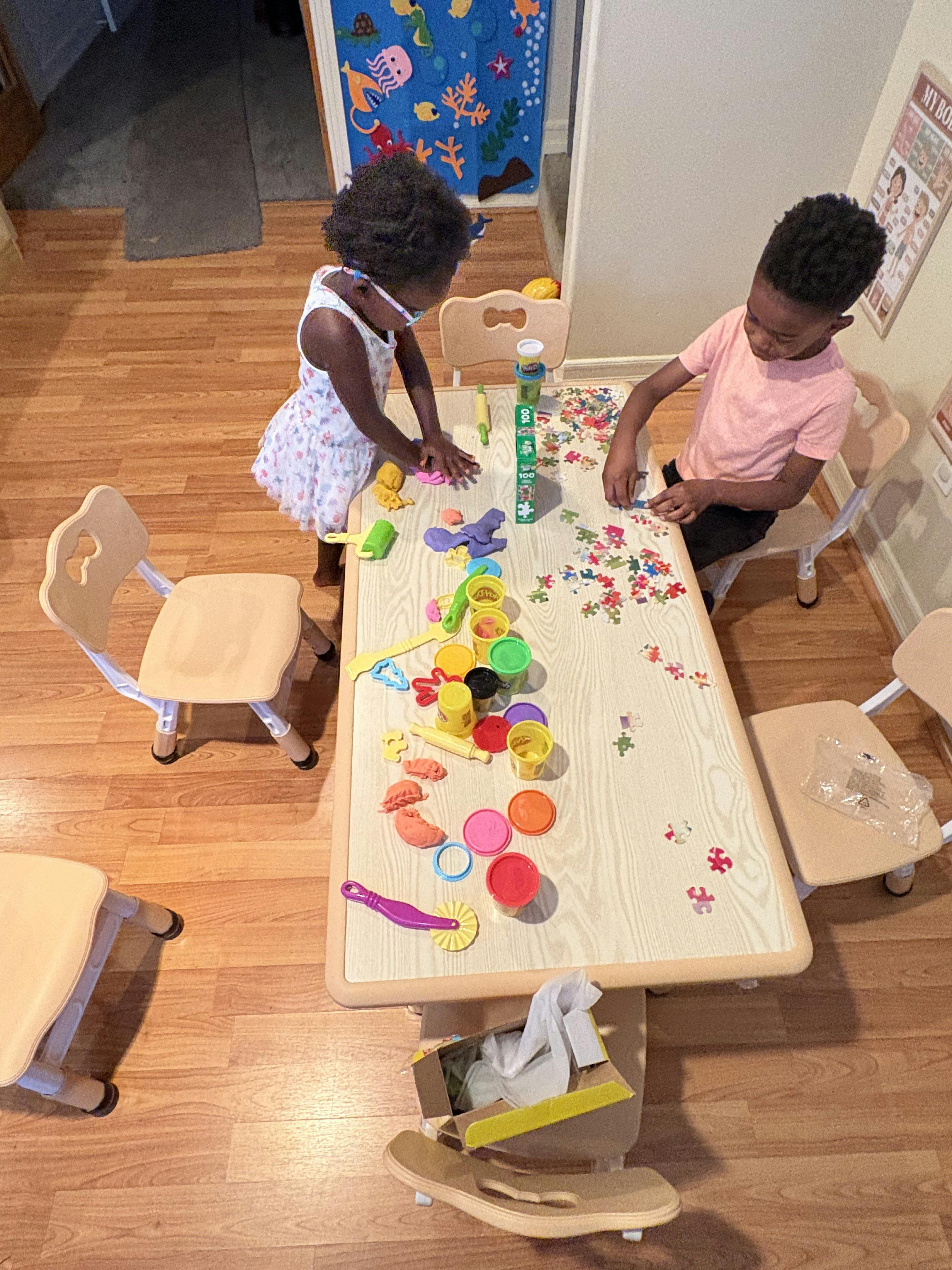 Two children playing with toys at a table
