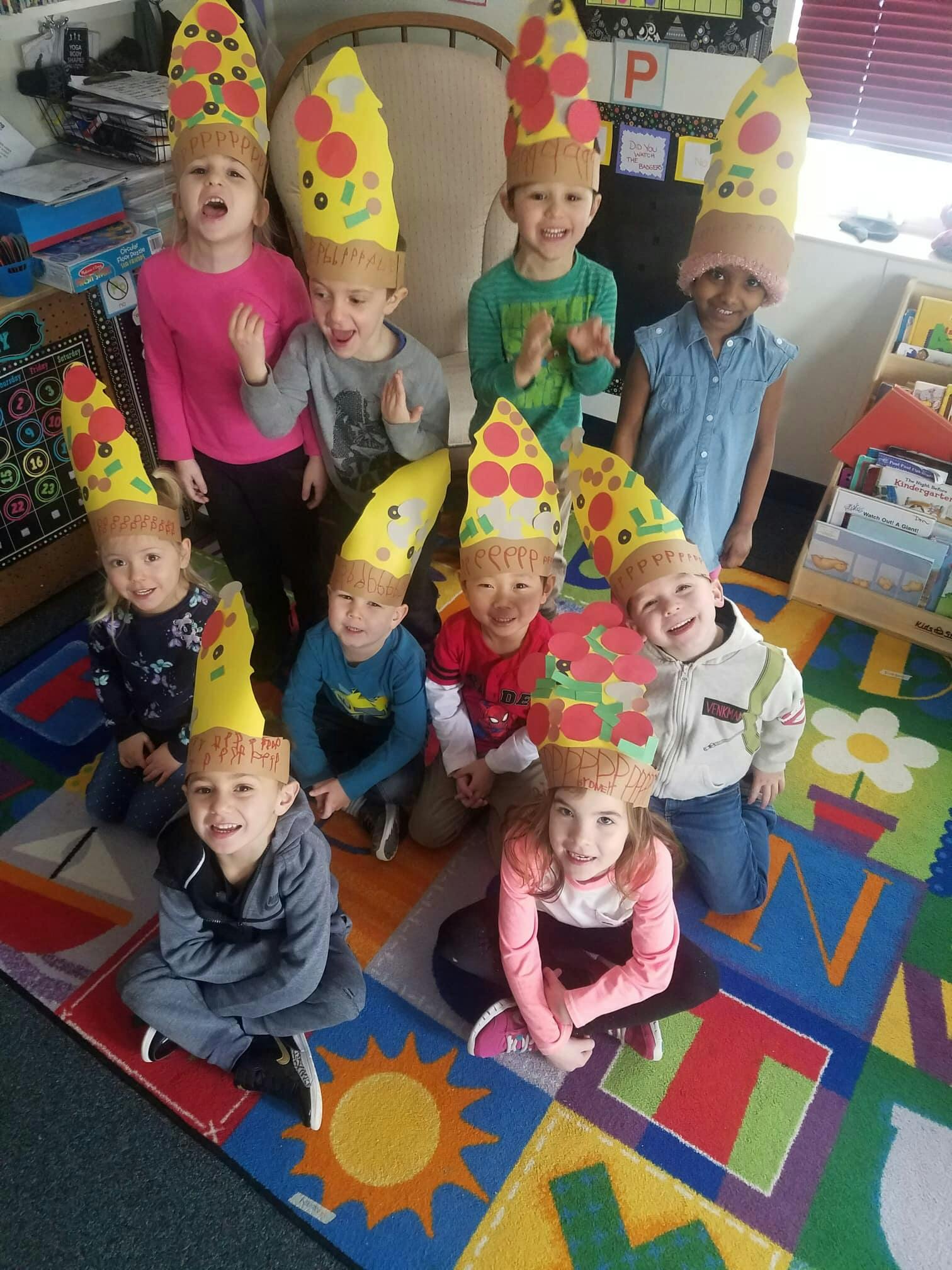 Group of children wearing pizza slice hats