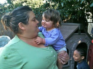 Person holding a child, both looking at each other