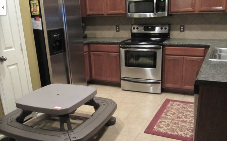 Kitchen with stainless steel appliances and a small picnic table