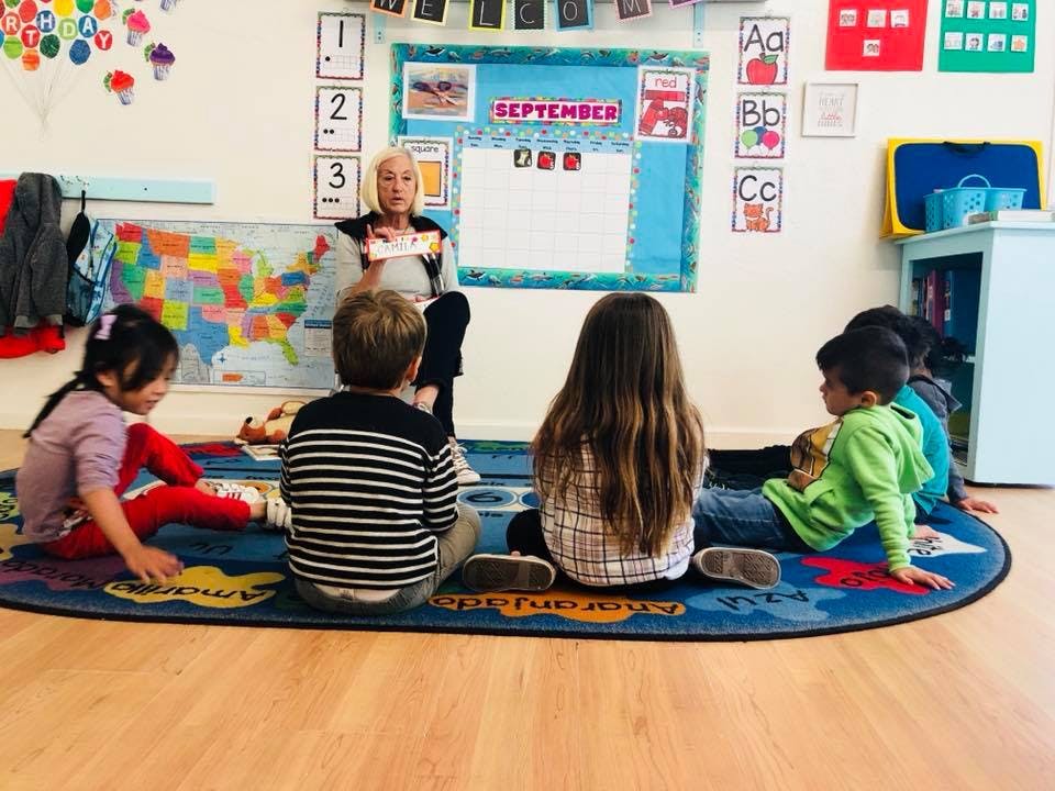 Adult reading to children in a classroom