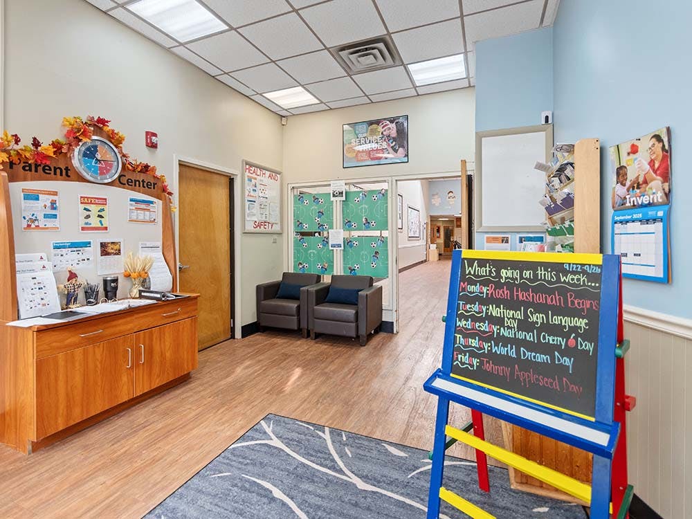 Lobby area of a parent center with a counter, seating, and a chalkboard sign