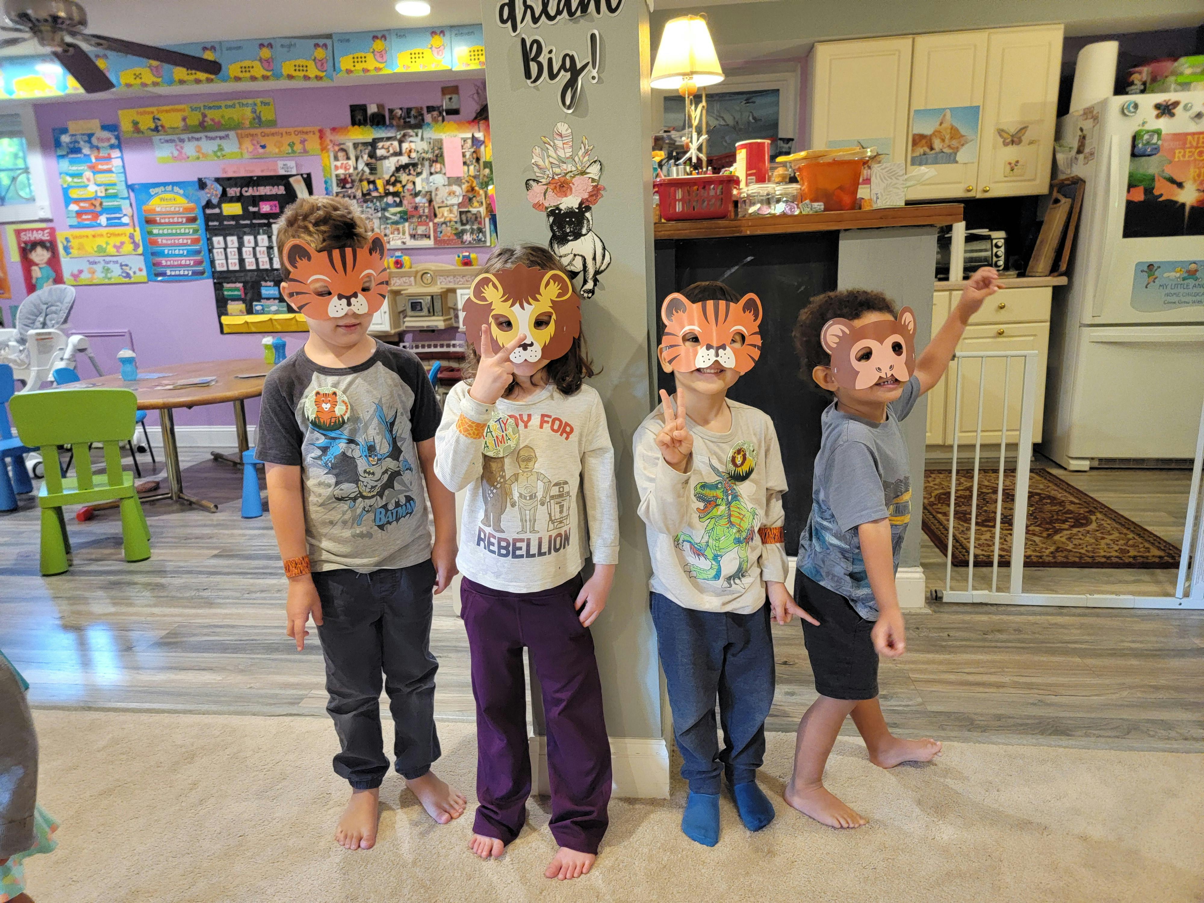 Four children wearing animal masks