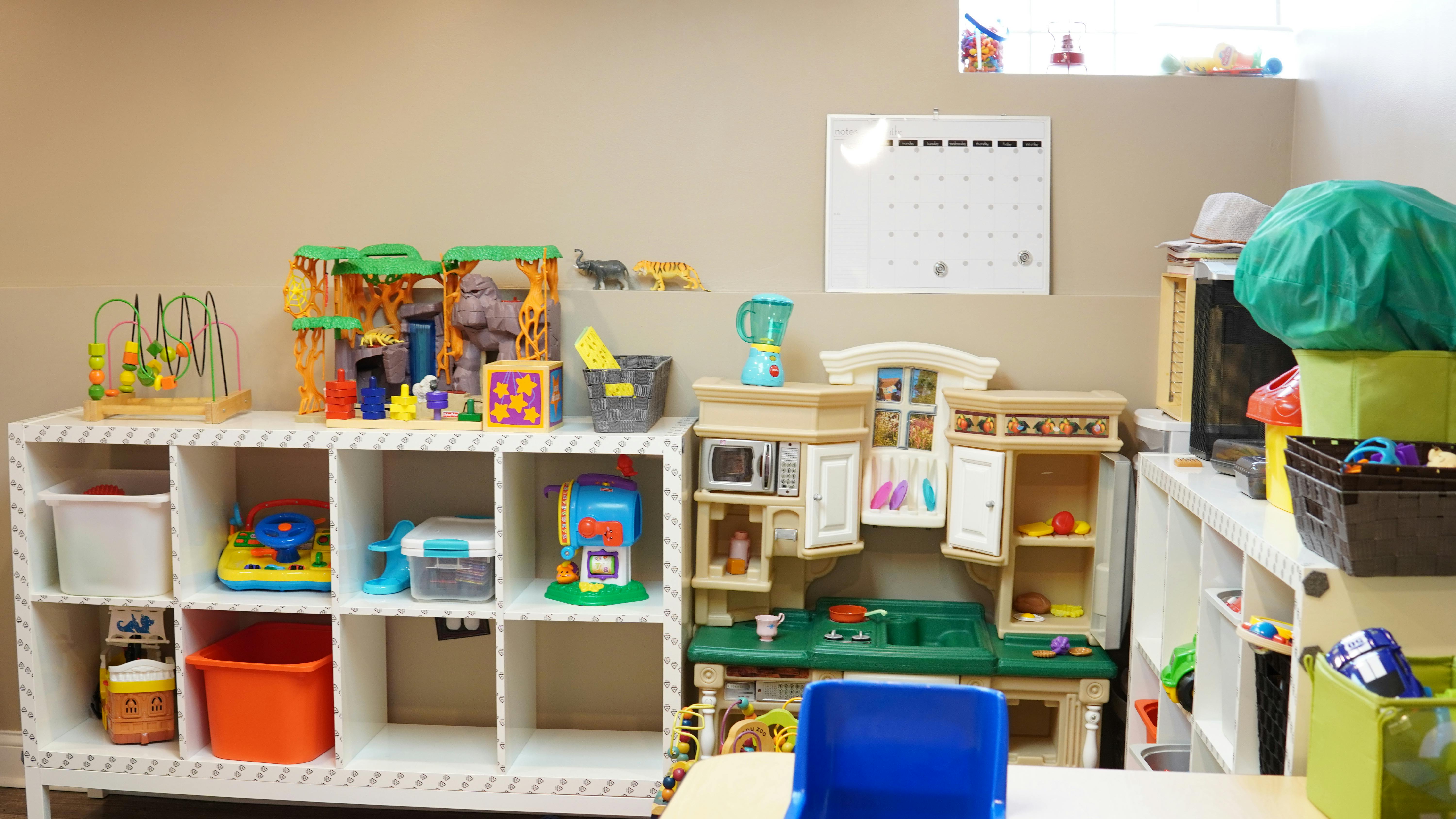 Playroom with shelves of toys and a play kitchen