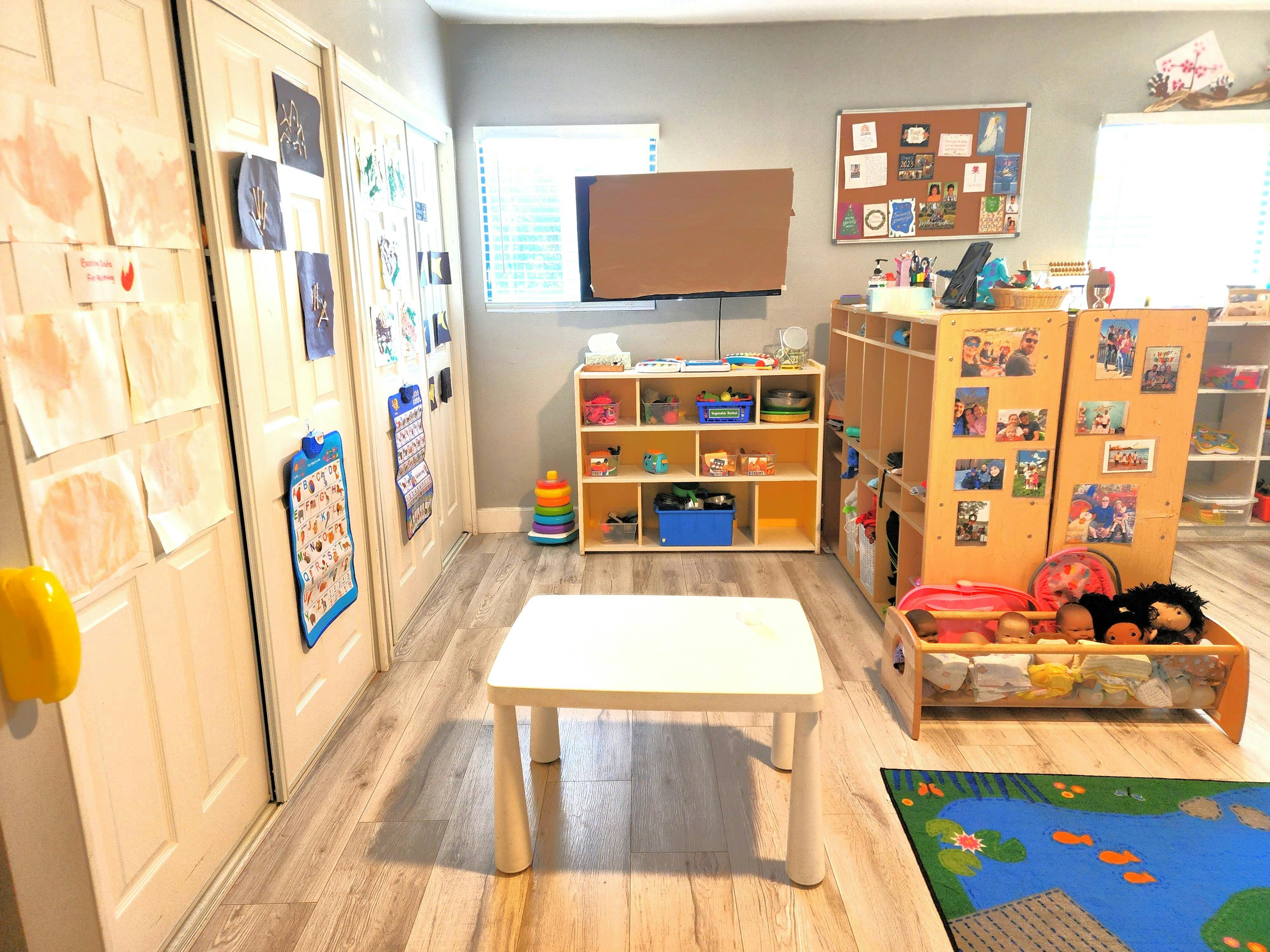 Playroom with small table, shelves, and cubbies with toys