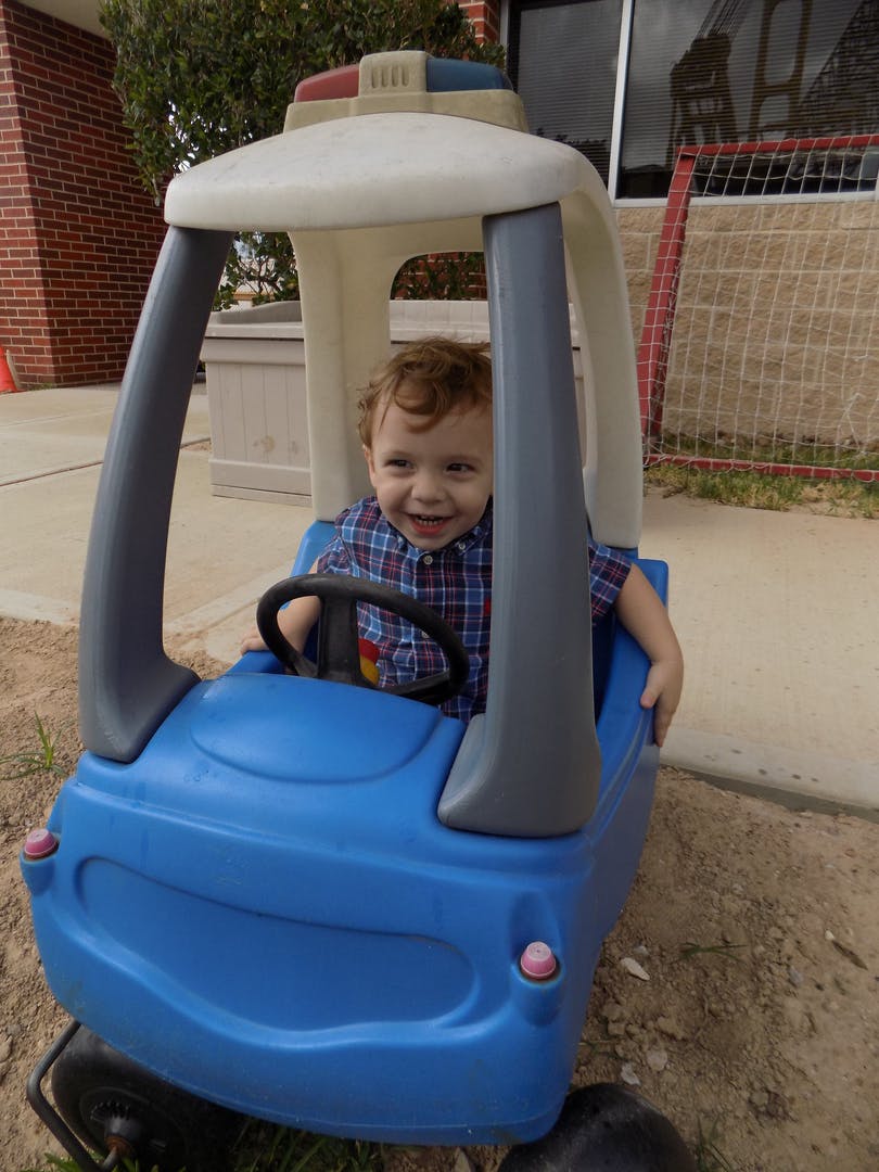 Child in a blue toy car