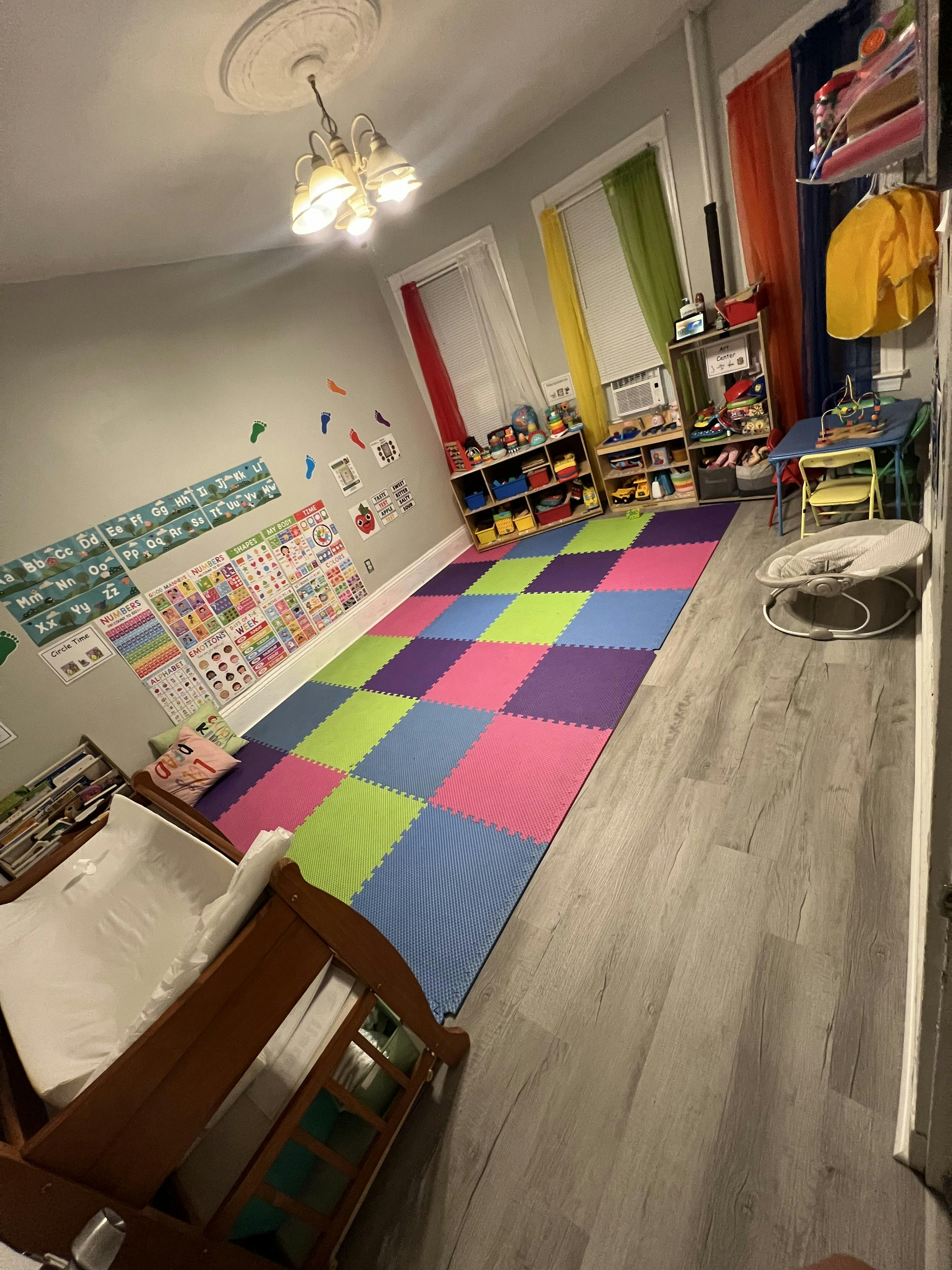 Playroom with colorful floor mats and shelves of toys
